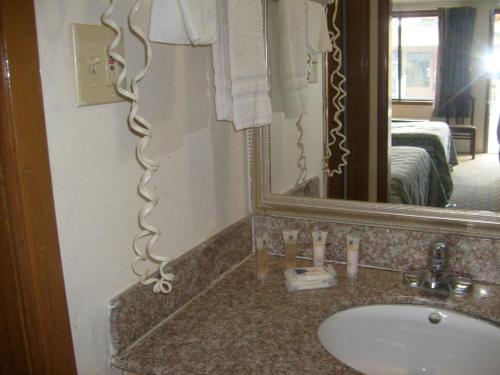 a bathroom with a sink and a large mirror at Express Inn Thomson in Thomson