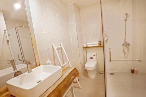 a bathroom with a sink and a shower and a toilet at ÉTÉ Dalat in Da Lat