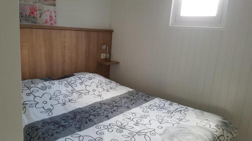 um pequeno quarto com uma cama e uma janela em vakantiehuisje Cottage em Aagtekerke