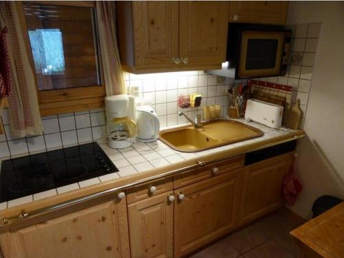 a kitchen counter with a sink and a microwave at Le Lièvre Blanc, appartement N°2 in Les Contamines-Montjoie