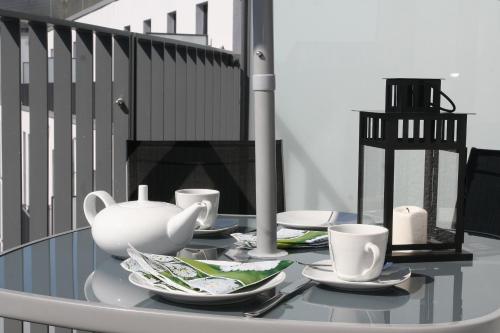 a glass table with plates and cups on a balcony at Holiday at Alexanderplatz Apartments in Berlin