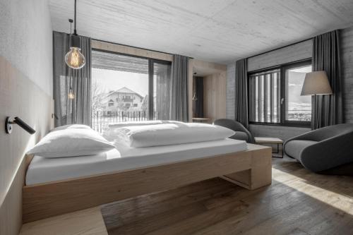 ブルーニコにあるHotel Krondlhofのベッドルーム(大きな白いベッド1台、椅子付)