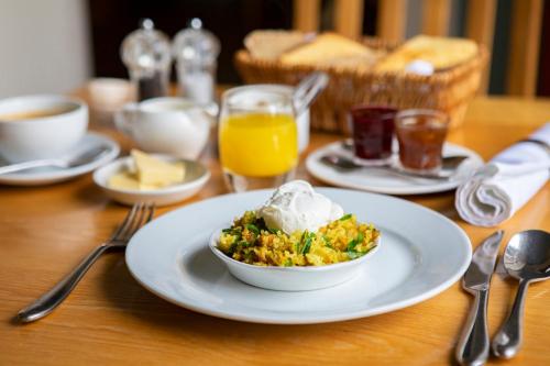 a table with a plate of food with a bowl of food at Trigony Hotel and Garden Spa in Closeburn