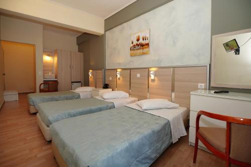a hotel room with four beds and a television at Socrates Hotel in Athens