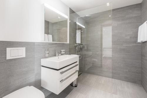 un bagno con un lavandino bianco e una doccia di LAAX Homes - Taviarna Laax 4,5 a Laax