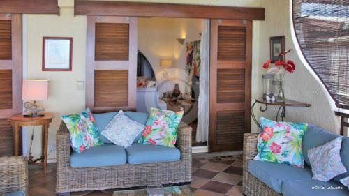 a living room with two wicker chairs and a couch at Fantastic spacious beachfront VILLAVACANCES in Grand Baie