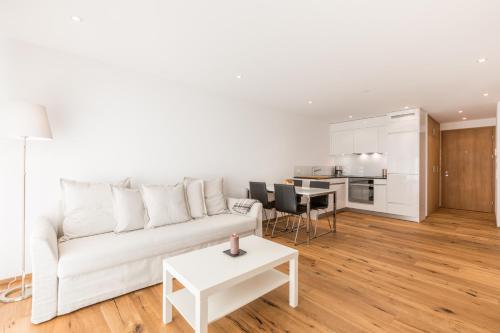 un soggiorno bianco con divano bianco e tavolo di LAAX Homes - Taviarna Laax 4,5 a Laax