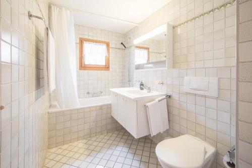 ラアにあるLAAX Homes - Val Mulin 14,1 - Accerneroの白いバスルーム(トイレ、シンク付)