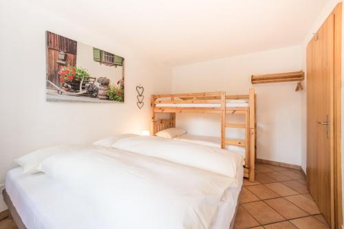ラアにあるLAAX Homes - Val Mulin 14,1 - Accerneroのベッドルーム1室(ベッド2台、二段ベッド1組付)