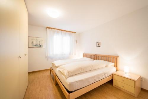 Un dormitorio con una cama grande y una ventana en LAAX Homes - Val Mulin 8,2 - Scarpazza, en Laax