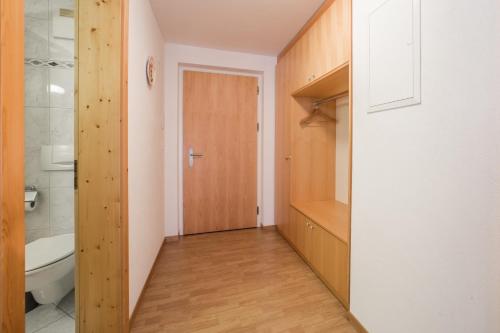 Łazienka z drewnianymi drzwiami, umywalką i toaletą w obiekcie LAAX Homes - Val Mulin 8,2 - Scarpazza w mieście Laax