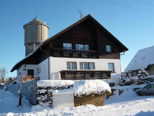 a house with a silo in the snow at Pension Pugner in Vysoké nad Jizerou