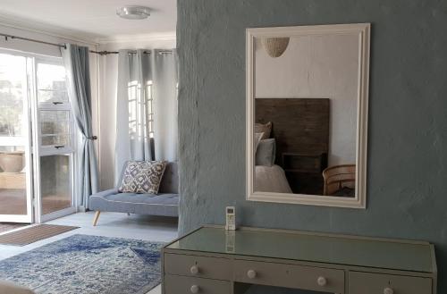 a living room with a mirror on a wall at Emmaus Apartment in Bloemfontein