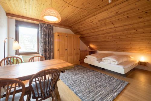 uma sala de jantar com uma mesa e uma cama num quarto em LAAX Homes - Val Signina 8-17 em Laax