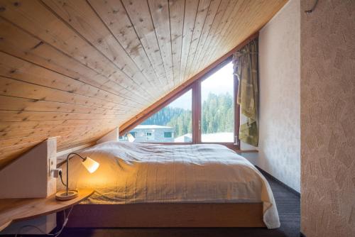 a large bed in a room with a large window at LAAX Homes - Val Signina 8-18 in Laax