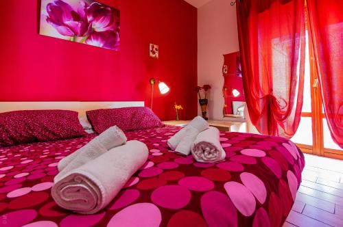 a pink bedroom with a bed with pink and white pillows at B & B San Cataldo in San Cataldo