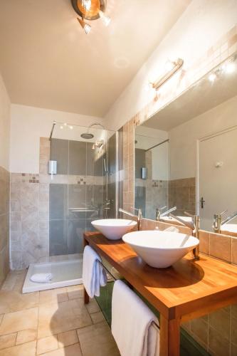 a bathroom with two sinks and a mirror and a tub at Logis Le Relais de Fusies in Lacaune