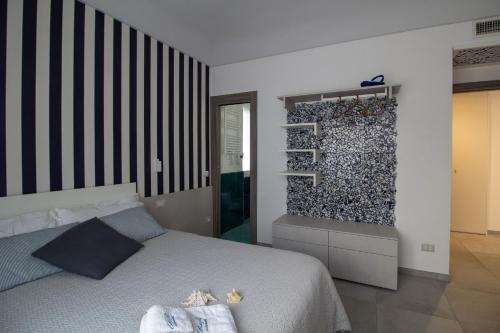 a bedroom with a bed and a wall of rocks at ChiàRò-La casa al mare in Minori