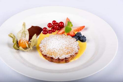 a plate with a dessert with fruit on it at Hotel San Lorenzo in Bormio