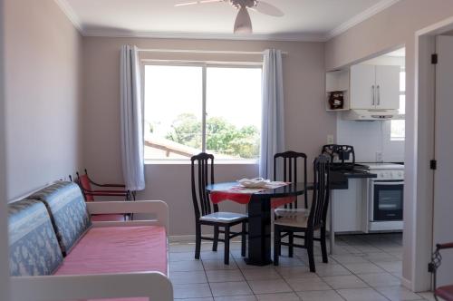a kitchen and living room with a table and chairs at Residencial Larissa Elena in Florianópolis