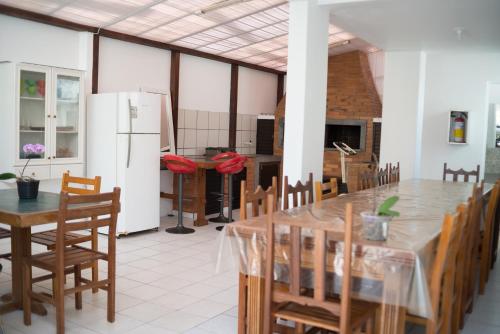 a kitchen with a table and chairs and a refrigerator at Residencial Larissa Elena in Florianópolis