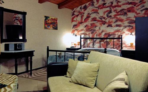 a living room with a couch in front of a wall at 4epoxesxenonas in Synikia Mesi Trikalon