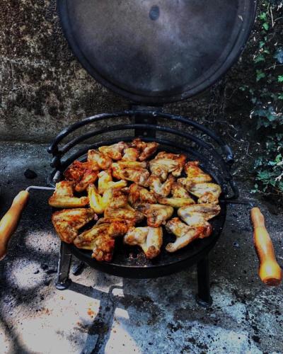 a grill with chicken and vegetables cooking on it at Apartments "Old house Pajovic" in Virpazar