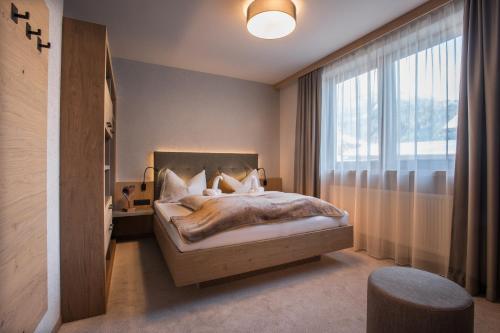 a bedroom with a bed and a large window at Birkenhof in Zell am Ziller