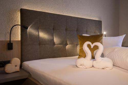 two white swans making a heart on a bed at Birkenhof in Zell am Ziller