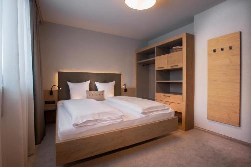 a bedroom with a large bed with a wooden headboard at Birkenhof in Zell am Ziller