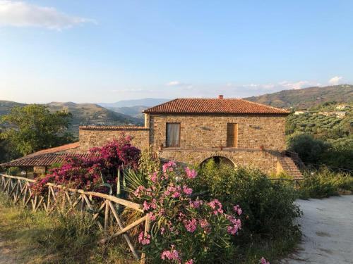 a stone house with flowers in front of it at Casa vacanze Il Mandorlo in Perdifumo