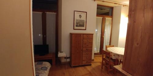 - une chambre avec une commode et un lit dans une pièce dans l'établissement Residence Le Carlton Cham, à Chamonix-Mont-Blanc
