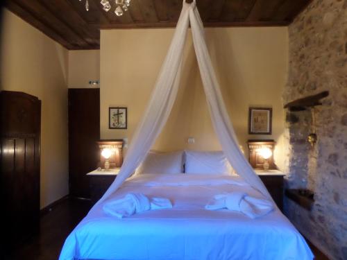 a bedroom with a bed with a mosquito net at Proselinos in Dhimitsana