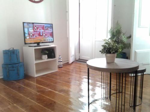 a living room with a table and a tv at Inglesinhos 1 in Lisbon