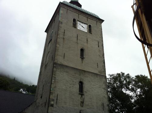 a tall brick tower with a clock on it at Central location in the heart of historic Bergen in Bergen
