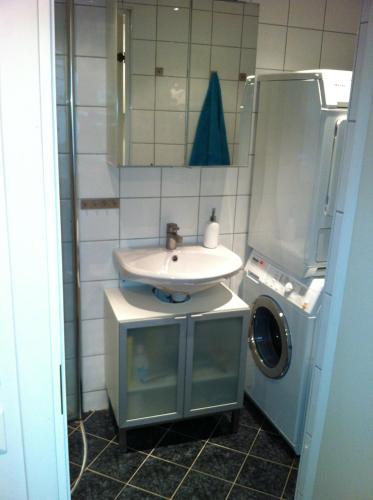 a bathroom with a sink and a washing machine at Central location in the heart of historic Bergen in Bergen