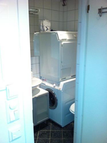 a bathroom with a washing machine and a washer at Central location in the heart of historic Bergen in Bergen