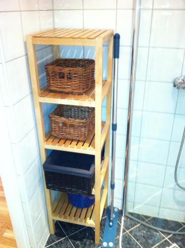 a wooden shelf with baskets on it in a bathroom at Central location in the heart of historic Bergen in Bergen