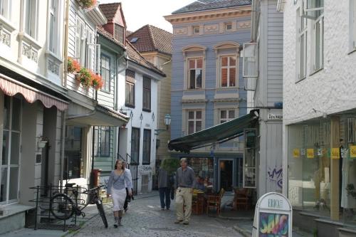 a man and a woman walking down a street at Central location in the heart of historic Bergen in Bergen