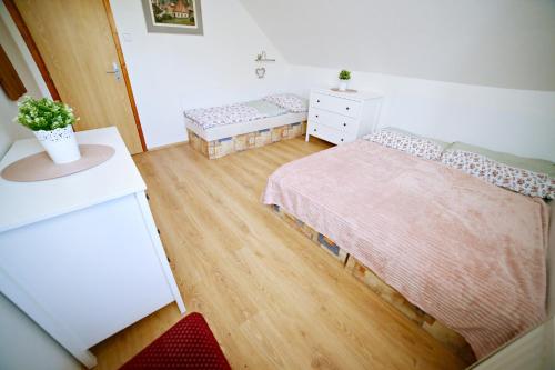 a small bedroom with two beds and a dresser at Restaurace a pension Chalupa in Vorder Třebau