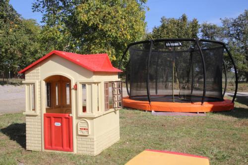 a toy house and a trampoline in the grass at Restaurace a pension Chalupa in Vorder Třebau