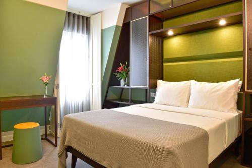 ein Schlafzimmer mit einem großen Bett und einer grünen Wand in der Unterkunft My Story Hotel Augusta in Lissabon