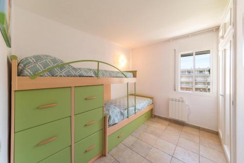 a bedroom with two bunk beds and a window at Apartment Elena in L'Escala