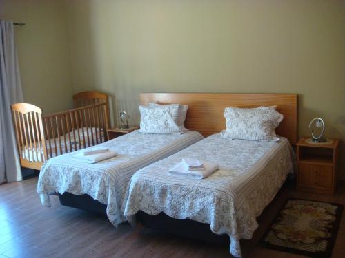 a bedroom with two beds with towels on them at Casa De Hospedes Flor Do Jardim in Malveira