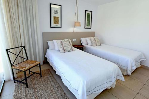 2 łóżka w pokoju z krzesłem i stołem w obiekcie Salobre Par 4 Nº4 w mieście Salobre