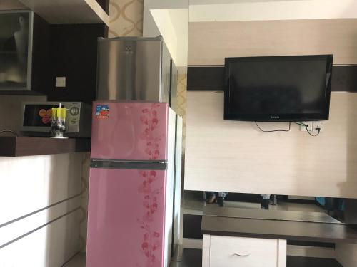 a kitchen with a refrigerator and a flat screen tv at Imam Bojol Street No 1 kampung utama Batam in Nagoya