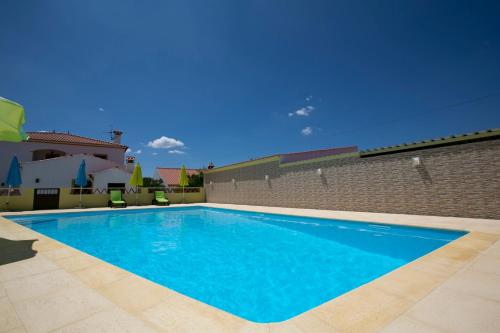 a large blue swimming pool in front of a brick wall at Tapada da Beirã in Marvão