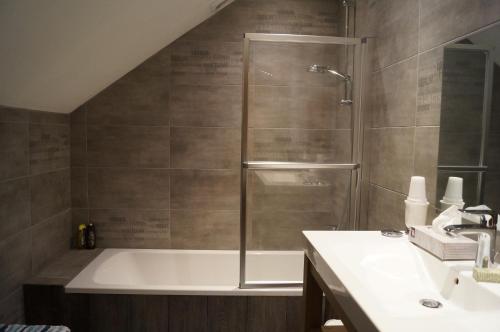 y baño con ducha, bañera y lavamanos. en La Petite Maison en Sart lez Walhain