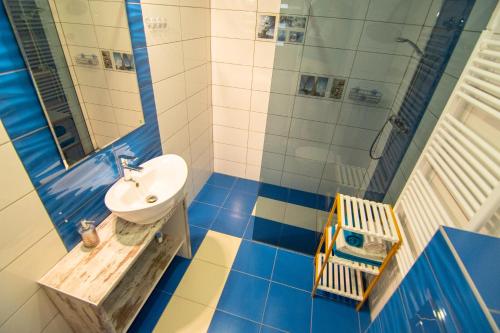 a blue and white bathroom with a sink and a shower at Apartmani Dalmacjia in Grebaštica