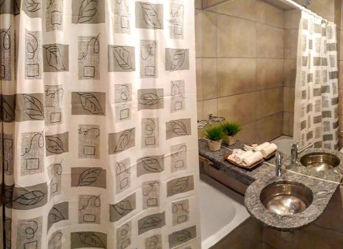 a bathroom with a shower curtain with a sink at Departamento - Edificio Costanera in San Salvador de Jujuy